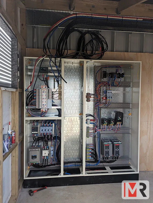 Installed switchboard with drives, contactors and cable tray in a plant room