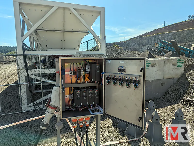 Stainless steel control panel open at a quarry feeder, drives and contactors inside