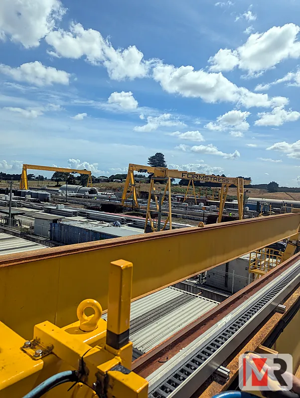 View along an overhead gantry crane rail across an industrial yard