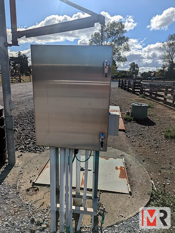 Stainless pump control panel beside a bore head on a farm