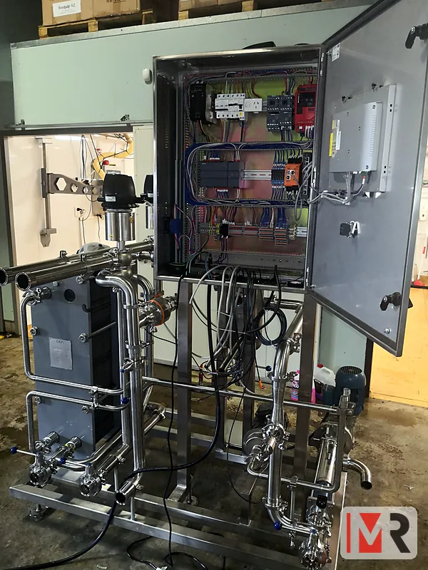 Stainless control panel installed on a process skid with heat exchanger and valves